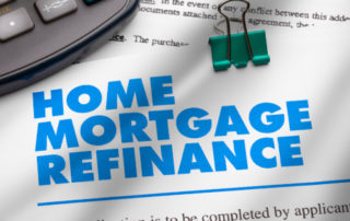 home mortgage refinance document with a paperclip on it and a calculator next to it