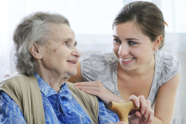 an elderly lady smiling at a younger woman